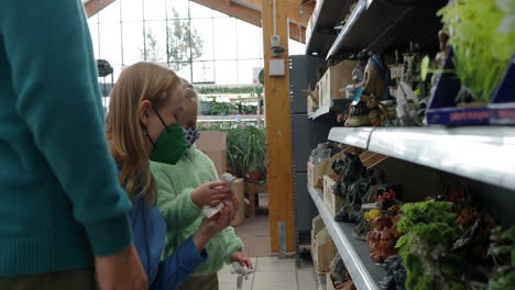 Mother-with-children-choosing-aquarium-decoration-items-in-the-shop