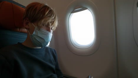 Teenage-boy-in-mask-using-the-phone-in-plane