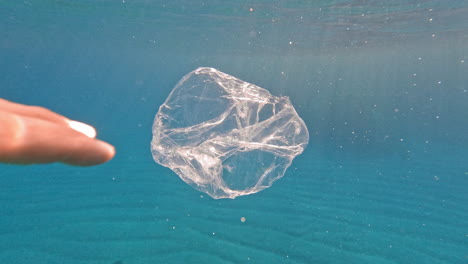Ocean-pollution---taking-plastic-bag-from-the-sea