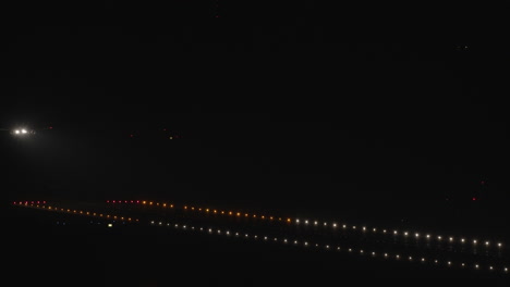 Wide-shot---airplane-landing-at-night