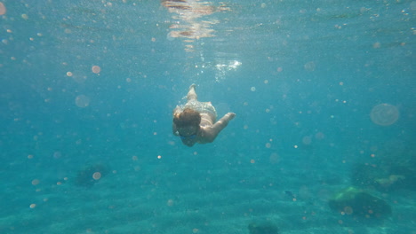 Slow-motion---teenager-swims-underwater-in-the-sea