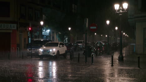 Calle-Nocturna-Con-Coche-En-Movimiento-Bajo-La-Fuerte-Lluvia.