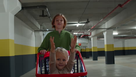 Brother-pushes-his-sister-in-a-shopping-cart
