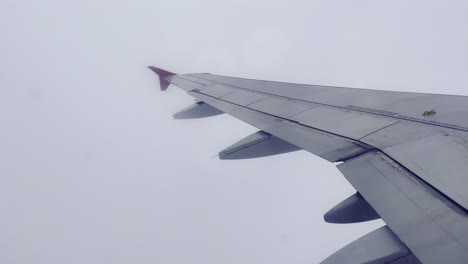 Der-Flügel-Eines-Fliegenden-Passagierflugzeugs-Inmitten-Dichter-Wolken-Am-Himmel