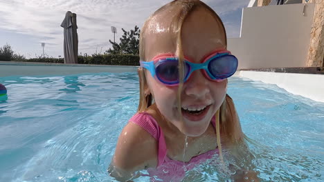 Girl-playfully-splashing-pool-water