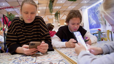 Mom-and-kids-are-on-their-phones-in-a-cafe---1