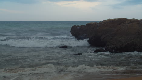 Ocean-waves-crashing-on-big-bolder-at-evening-Portugal