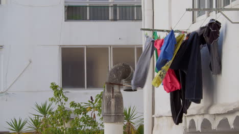 Laundry-Drying-in-the-Wind-Against-White-Wall