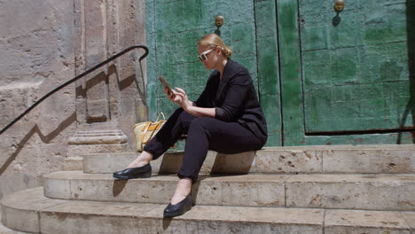 A-young-woman-is-sitting-on-stone-steps