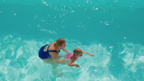 Mother-teaching-daughter-to-swim