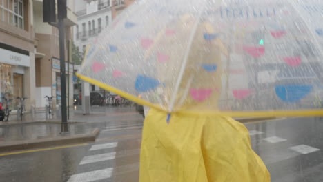 Mädchen-Im-Gelben-Regenmantel-Unter-Einem-Regenschirm