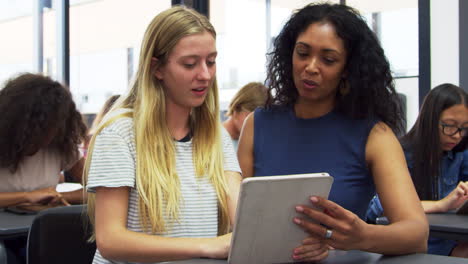 Teacher-helps-blonde-teenage-schoolgirl-use-tablet-computer