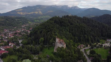 Sideway-tracking-drone-shot-of-Bran-castle-in-Brasov-cityscape-in-Romania