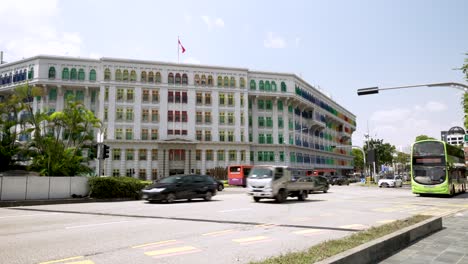 A-static-shot-of-daily-traffic-passing-in-front-of-the-Old-Hill-Police-Station,-the-historical-building-is-home-to-the-Ministry-of-Communications-and-Information-in-Singapore