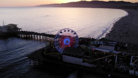 Dusk-sunset-drone-shot-pulling-back-from-lit-up-santa-monica-pier