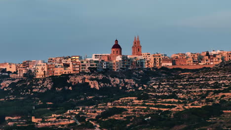 Aerial-view-cliffs-and-the-Mellieha-parish-church,-dramatic-evening-in-Malta