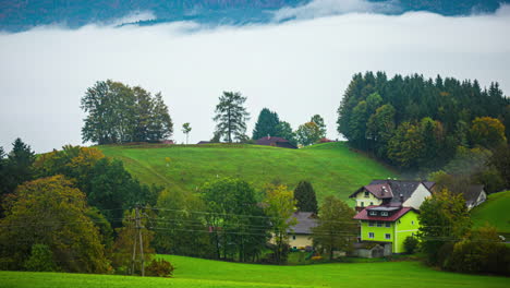 Foggy-hillside-with-residential-houses-in-a-village-near-Attersee,-Austria