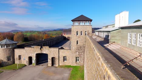 Campo-De-Concentración-De-Mauthausen,-Alambre-De-Púas-En-La-Parte-Superior-De-Las-Paredes-Con-La-Puerta-Principal-Y-La-Torre-De-Vigilancia-En-La-Alta-Austria