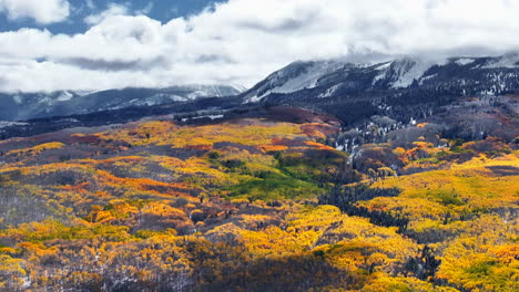 Kebler-Pass-aerial-cinematic-drone-Crested-Butte-Gunnison-Colorado-seasons-collide-early-fall-aspen-tree-red-yellow-orange-forest-winter-first-snow-powder-Rocky-Mountain-peak-circle-right-motion