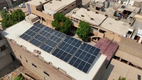 Vista-Aérea-De-Filas-De-Paneles-Solares-En-El-Techo-De-Un-Edificio-En-Shahdadpur,-Sindh