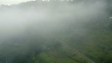 Establishing-Aerial-Drone-Shot-through-the-Mist-of-Train-Track-in-Hills-around-Ella-Sri-Lanka