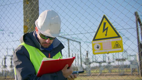 Supervisor-reading-work-report-outside-secured-hazardous-location