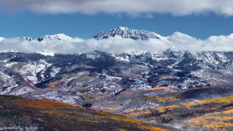 Kebler-Pass,-Filmische-Luftaufnahme,-Drohne,-Crested-Butte,-Gunnison,-Colorado,-Jahreszeiten-Kollidieren,-Frühherbst,-Espe,-Rot,-Gelb,-Orange,-Wald,-Winter,-Erster-Schnee,-Pulver,-Felsiger-Berggipfel,-Wolken,-Kreis,-Bewegung-Nach-Links