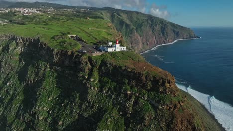 Der-Drohnenrückzug-Errichtet-Die-Steile-Klippenküste-Von-Madeira,-Portugal,-Mit-Einem-Leuchtturm-An-Einem-Malerischen-Punkt