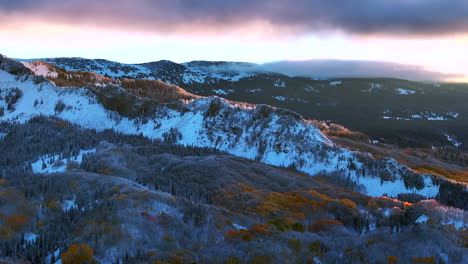 Erstes-Licht-Kebler-Pass-Crested-Butte-Gunnison-Colorado-Jahreszeiten-Absturz-Luftdrohne-Frühherbst-Espenbaum-Rot-Gelb-Orange-Wald-Winter-Erster-Schnee-Kalt-Sonnenaufgang-Wolke-Felsige-Berggipfel-Linke-Bewegung