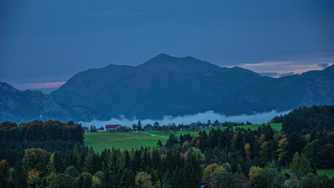 Mountain-mist-moves-in-valley-during-sunset-timelapse,-landscape-view