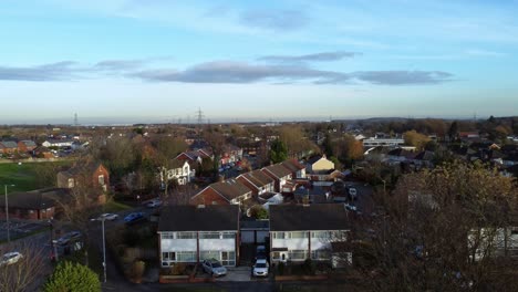 Aerial-view-rising-above-Rainhill-village-housing-estate-and-busy-road-on-vast-rural-British-landscape