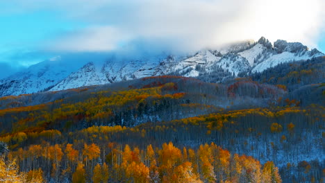 Timelapse-Kebler-Pass-Crested-Butte-Gunnison-Colorado-seasons-collide-aerial-drone-early-fall-aspen-tree-red-yellow-orange-forest-winter-first-snow-cold-sunrise-clouds-on-Rocky-Mountain-peaks-zoom-out