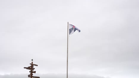 Angra-do-Heroismo-flag-waving-on-windy-and-moody-day,-view-from-below