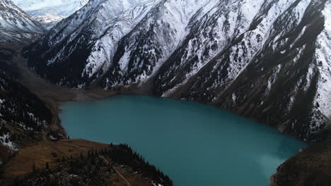 Aerial-tilt-shot-overlooking-the-Big-Almaty-Lake-and-snowy-mountains-of-Kazakhstan