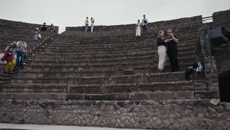 Tourists-mingle-in-Pompeii's-Great-Theatre-ruins,-Italy