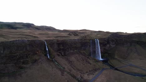 Mystical-waterfall-Seljalandsfoss-in-volcanic-mountain-panorama,-aerial