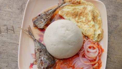 Dish-with-banku,-typical-Ghanaian-dumpling,-accompanied-by-fish-and-other-garnishes,-African-cuisine