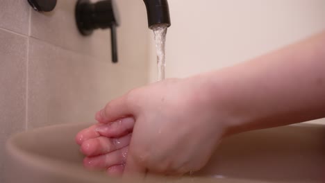 Person-wash-hands-without-soap-in-modern-sink,-close-up