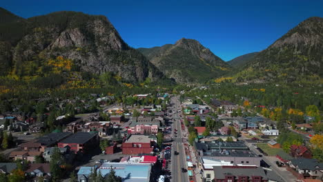 Downtown-Frisco-Colorado-aerial-cinematic-drone-traffic-Main-Street-early-yellow-fall-colors-Aspen-trees-morning-Lake-Dillon-Keystone-Breckenridge-Silverthorne-Ten-Mile-Range-blue-sky-forward-motion