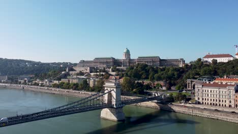 Drone-view-over-Danube-River-of-Széchenyi-Chain-Bridge-and-Buda-Castle,-Budapest