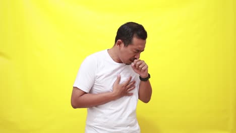 Asian-adult-man-coughing-on-yellow-background