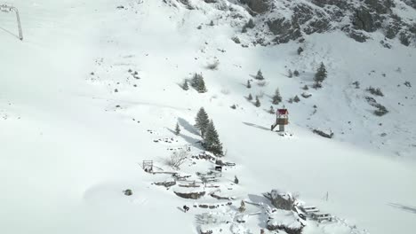 Seilbahn-An-Einem-Berghang,-Wo-Touristen-Mitfahren,-Um-Die-Aussicht-Auf-Eine-Verschneite-Landschaft-In-Engelberg,-Brunni,-In-Bahnen,-Schweiz,-Zu-Genießen