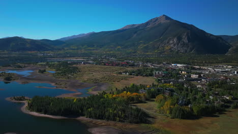 Early-fall-colors-Aspen-trees-downtown-Frisco-Main-Street-Lake-Dillon-islands-Colorado-aerial-cinematic-drone-morning-view-Frisco-Breckenridge-Silverthorne-Ten-Mile-Range-pan-up-reveal-forward-motion
