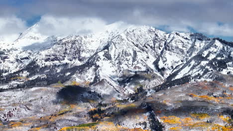 Kebler-Pass,-Filmische-Luftaufnahme,-Drohne,-Nachmittag,-Crested-Butte,-Gunnison,-Colorado,-Jahreszeiten-Kollidieren,-Frühherbst,-Espenbaum,-Rot,-Gelb,-Orange,-Wald,-Winter,-Erster-Schnee,-Pulver,-Felsiger-Berggipfel,-Rückbewegung