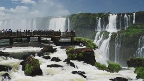 Tourist's-Looking-Over-onto-Beautiful-Waterfall-Scenery,-Picturesque-Views-of-Argentinian-Waterfalls-Hidden-in-Thick-Green-Rainforest-Tourism-Destination-at-Iguazu-Falls,-Brazil,-South-America