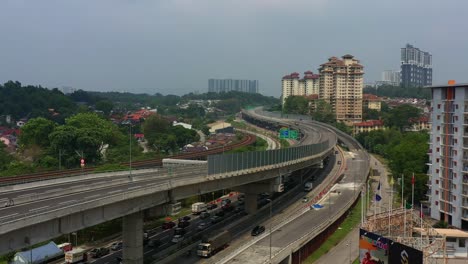 Drohnen-Höhenaufnahme-Aus-Der-Luft,-Die-Den-E37-Salak-Autobahn--Und-Unterführungsverkehr-Mit-Verschwommener-Skyline-In-Der-Stadt-Kuala-Lumpur,-Malaysia,-Südostasien,-Erfasst