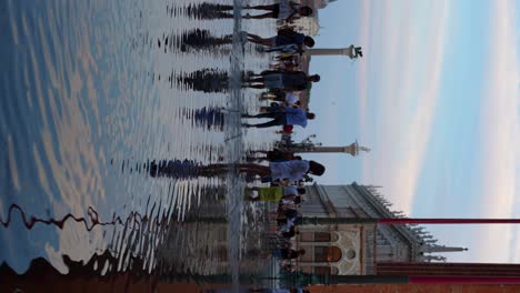 Many-tourists-walking-barefoot-in-the-flooded-Piazza-San-Marco-in-Venice,-Italy
