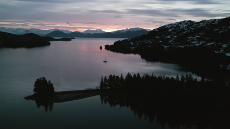 Aerial-view-around-a-sailboat-moored-in-the-West-Twin-Bay,-gloomy-dusk-in-Alaska