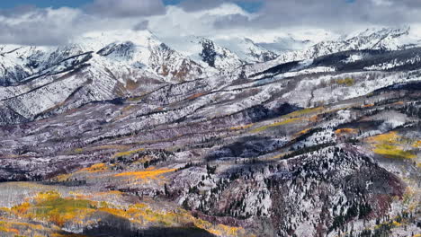 Kebler-Pass,-Filmische-Luftaufnahme,-Drohne,-Nachmittag,-Crested-Butte,-Gunnison,-Colorado,-Jahreszeiten-Kollidieren,-Frühherbst,-Espe,-Rot,-Gelb,-Orange,-Wald,-Winter,-Erster-Schnee,-Pulver,-Felsiger-Berggipfel,-Kreis-Rechts