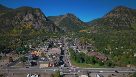 Downtown-Frisco-Colorado-aerial-cinematic-drone-traffic-Main-Street-early-yellow-fall-colors-Aspen-trees-morning-Lake-Dillon-Keystone-Breckenridge-Silverthorne-Ten-Mile-Range-blue-sky-pan-up-motion